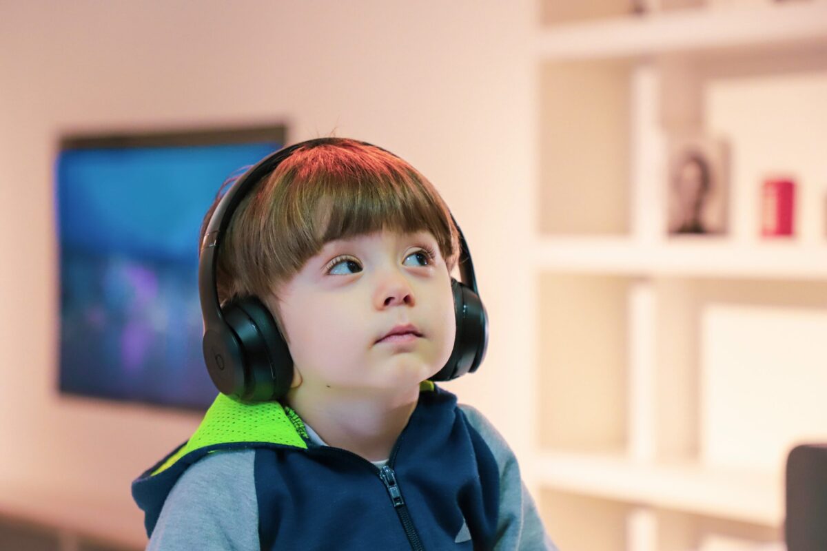 little boy is listening with headphone