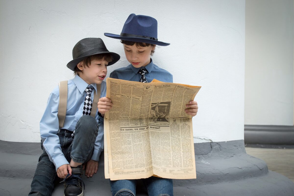 Two children are reading Newspaper