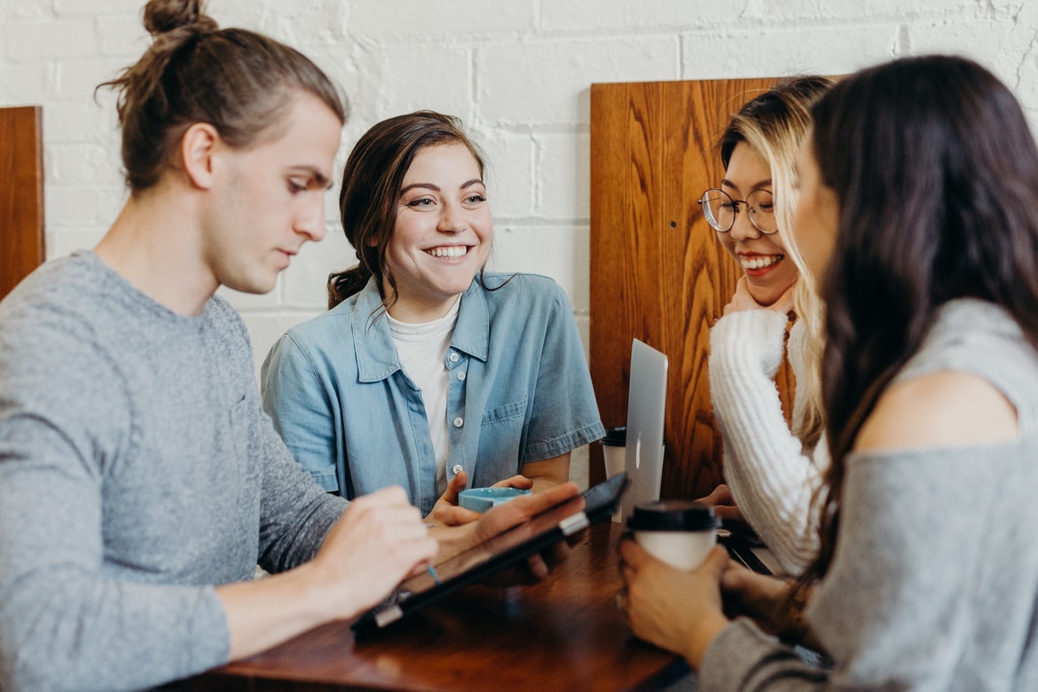 4 people talking each other in a meeting room.